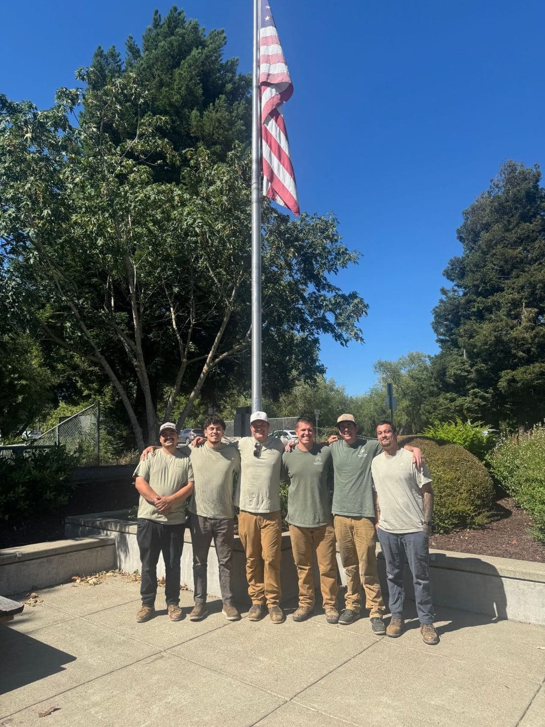 The Green Core Heating & Air team in front of an American flag